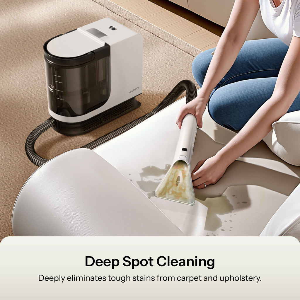 Portable spot cleaner with spray nozzle treating a stain on upholstery